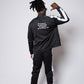 Men’s black slim-fit performance tracksuit with white side stripe detailing, featuring a zip-up jacket and tapered joggers, styled with white sneakers for a clean, athletic streetwear look built for comfort, confidence, and everyday performanc