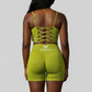 Women’s olive green rippled shorts set featuring high-waisted sculpting biker shorts with butt-lifting design and a strappy adjustable crisscross back sports bra, designed to enhance curves, smooth cellulite, and deliver a flattering, confident athletic look.