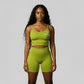 Women’s olive green rippled shorts set featuring high-waisted sculpting biker shorts with butt-lifting design and a strappy adjustable crisscross back sports bra, designed to enhance curves, smooth cellulite, and deliver a flattering, confident athletic look.