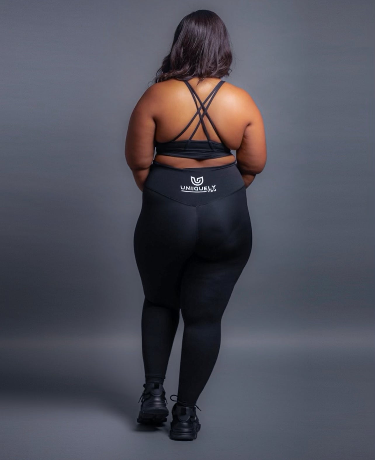 Black seamless workout set with cross-back strappy sports bra and high-waisted leggings featuring butt lifting design, waist-slimming fit, and smooth sculpting