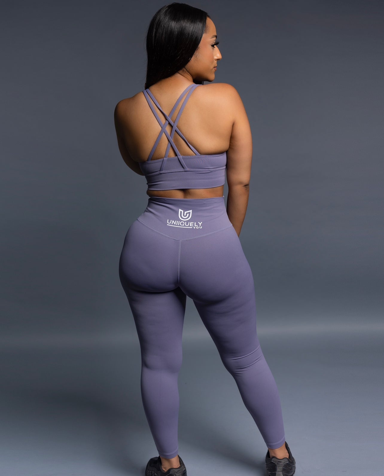 Purple seamless workout set with cross-back strappy sports bra and high-waisted leggings featuring butt lifting design, waist-slimming fit, and smooth sculpting fabric