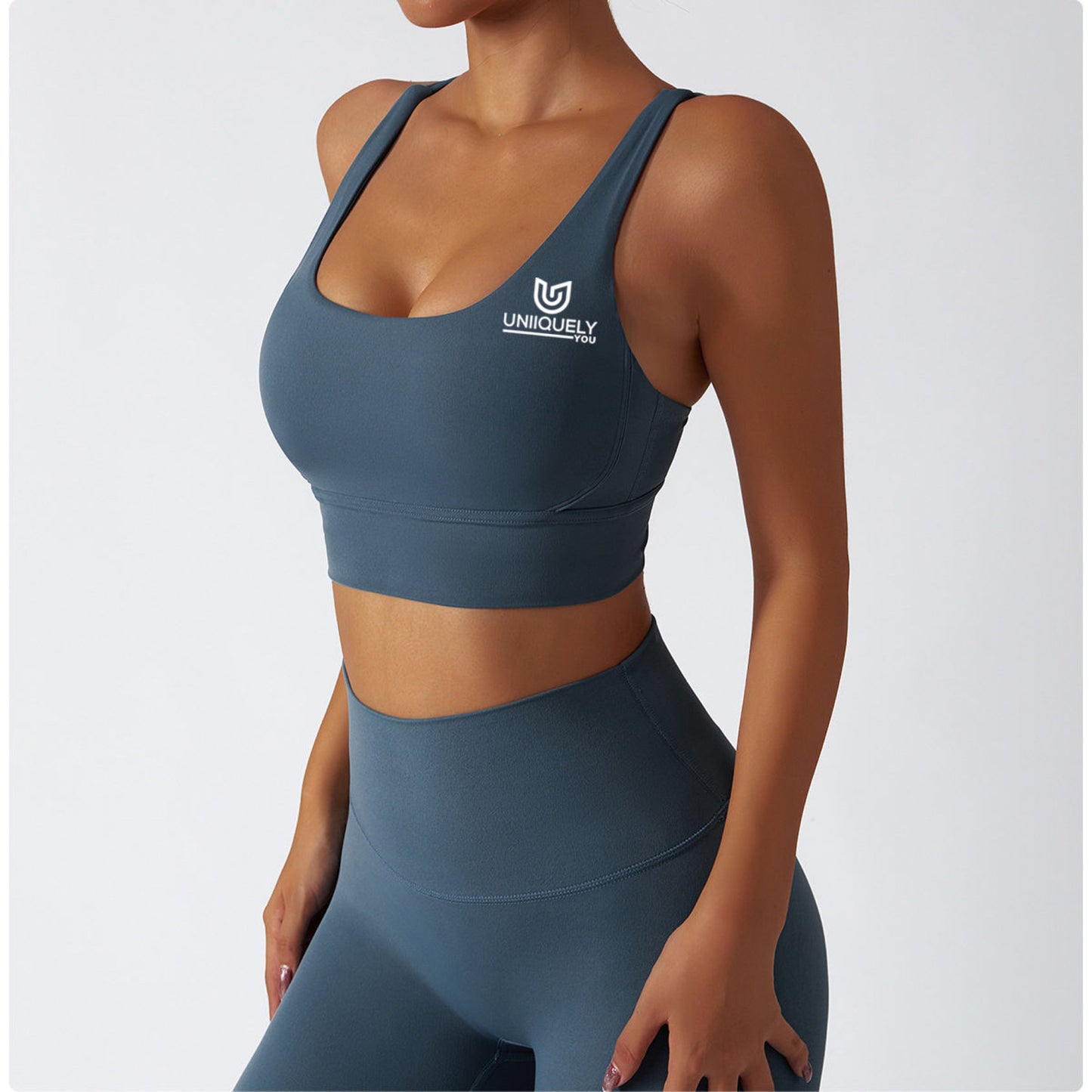 Teal blue seamless workout set with cross-back sports bra and high-waisted leggings featuring butt lift design, waist-slimming fit, and smooth sculpting fabric