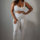Women’s grey rippled workout set with crossover high-waist leggings that slim the waist and enhance curves, paired with an adjustable cross-strap back sports bra for a sculpted, supportive, and flattering athletic look.
