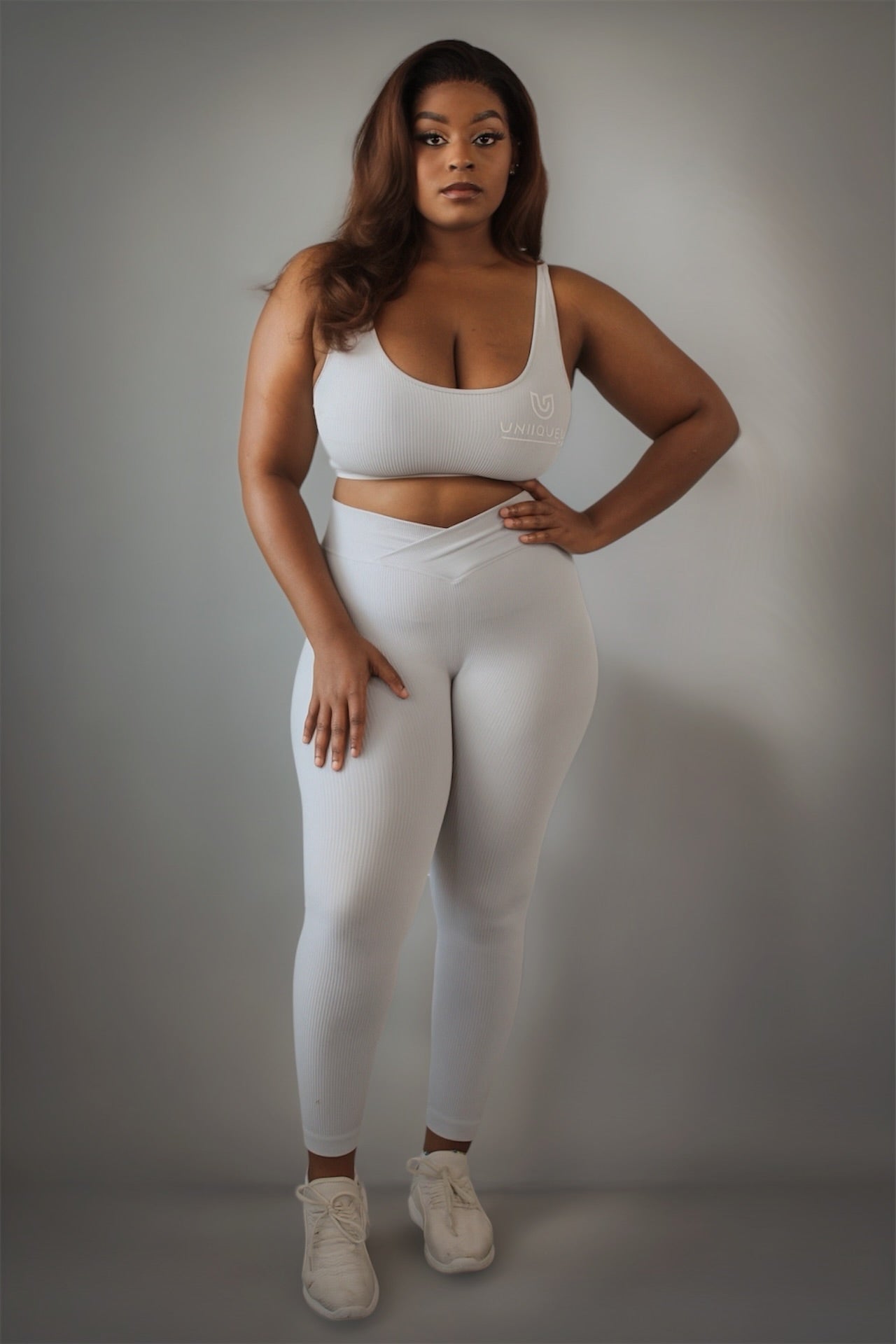 Women’s grey rippled workout set with crossover high-waist leggings that slim the waist and enhance curves, paired with an adjustable cross-strap back sports bra for a sculpted, supportive, and flattering athletic look.