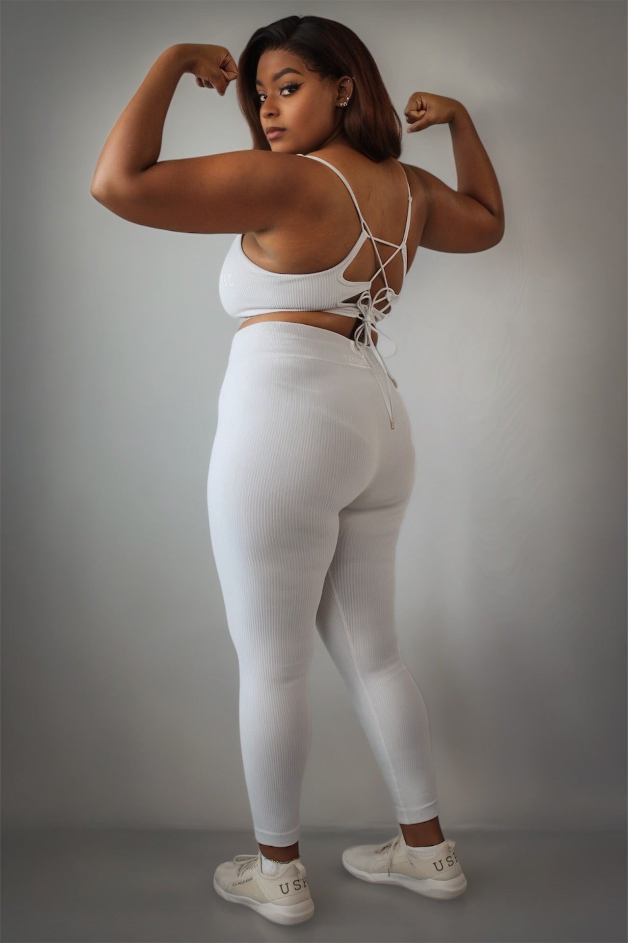 Women’s grey rippled workout set with crossover high-waist leggings that slim the waist and enhance curves, paired with an adjustable cross-strap back sports bra for a sculpted, supportive, and flattering athletic look.