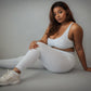 Women’s grey rippled workout set with crossover high-waist leggings that slim the waist and enhance curves, paired with an adjustable cross-strap back sports bra for a sculpted, supportive, and flattering athletic look.