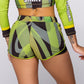 Women’s green multi-color two-piece workout set with long sleeve crop top and fitted athletic shorts, geometric striped activewear set